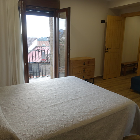 Habitación con cama de matrimonio y balcón exterior, en los apartamentos rurales Casa La Josefa de Fermoselle, con vistas a los Arribes del Duero.