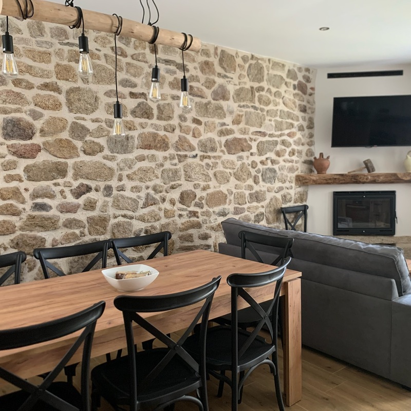  Zona de reunión familiar o de amigos en los apartamentos rurales Casa Josefa, con diseño rústico y paredes de piedra. 